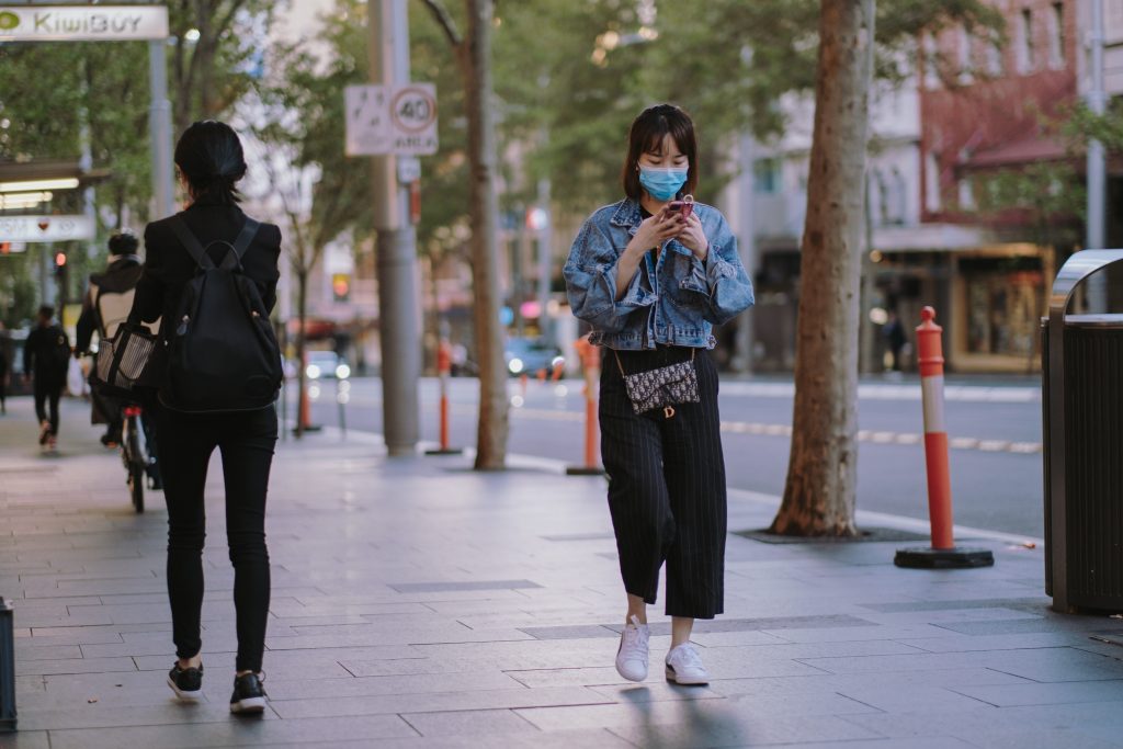woman with a face mask walking down the street during lockdown